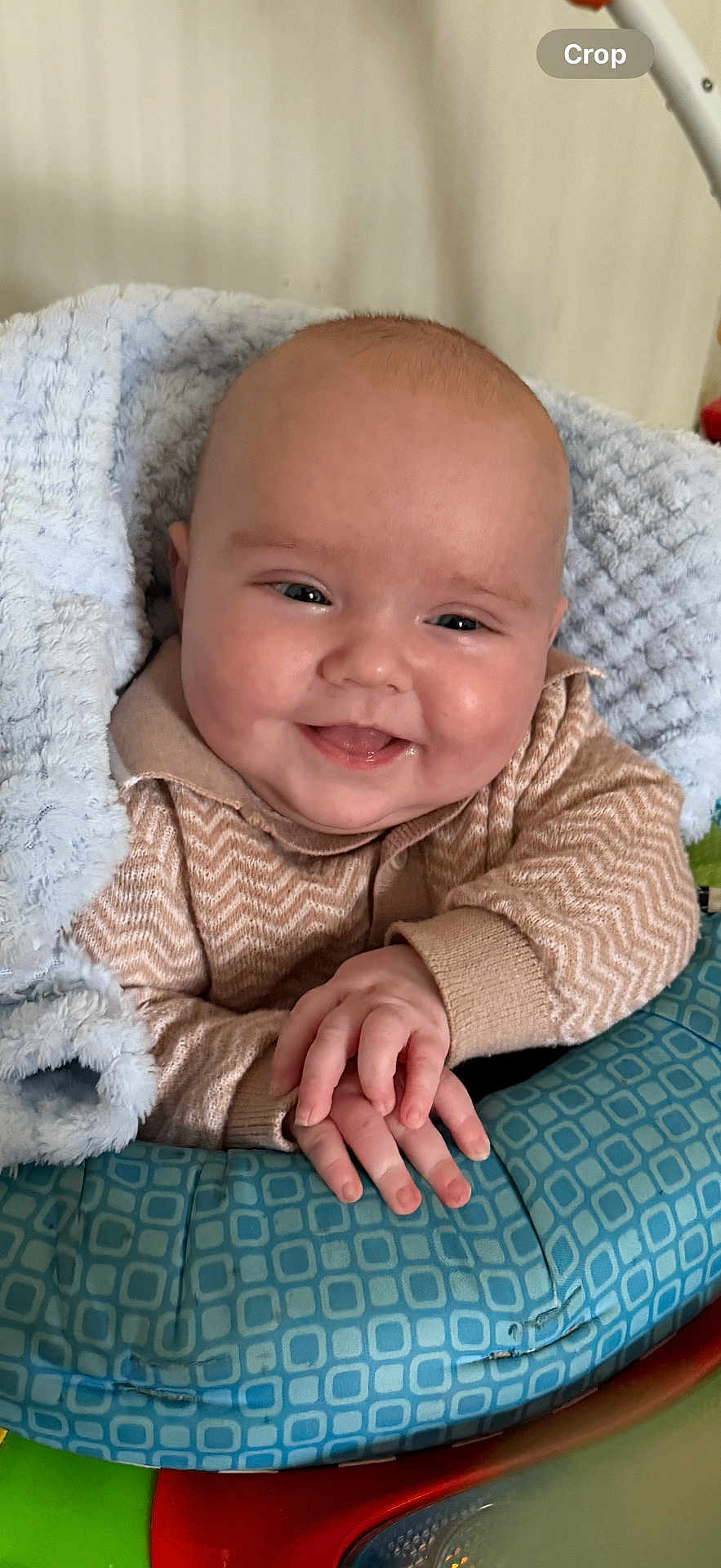 Elliott is registered to the contest to win money with this photo: baby, smiling, face, hands, blanket, sweater, blue_cushion, cozy, indoor, child, infant, cute, happy, portrait, soft, warm, closeup, person, newborn, comfort