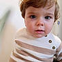 baby, blue_eyes, brown_hair, buttons, child, closeup, curious, cute, expression, face, head_and_shoulders, indoor, person, portrait, soft_light, striped_clothing, sweater, toddler, warm_colors, young_child