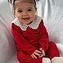 baby, child, smiling, red_clothing, white_collar, pigtails, sitting, happy, cute, portrait, indoor, cozy, sock, knitwear, infant, face, hands, blanket, young_child, expression