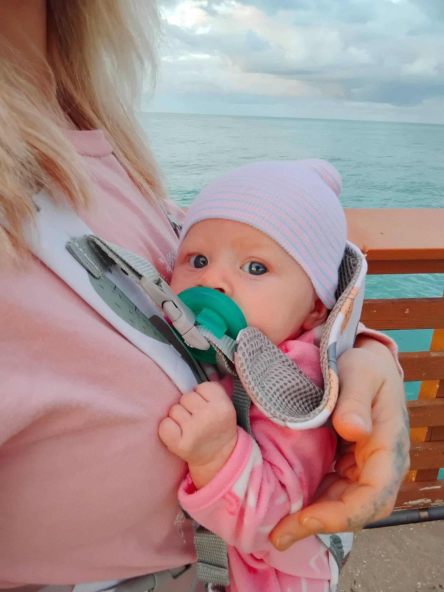baby, beanie, bench, bodypart, bonnet, cap, clothing, coat, face, finger, furniture, hand, hat, head, jacket, newborn, person, photography, portrait, wood