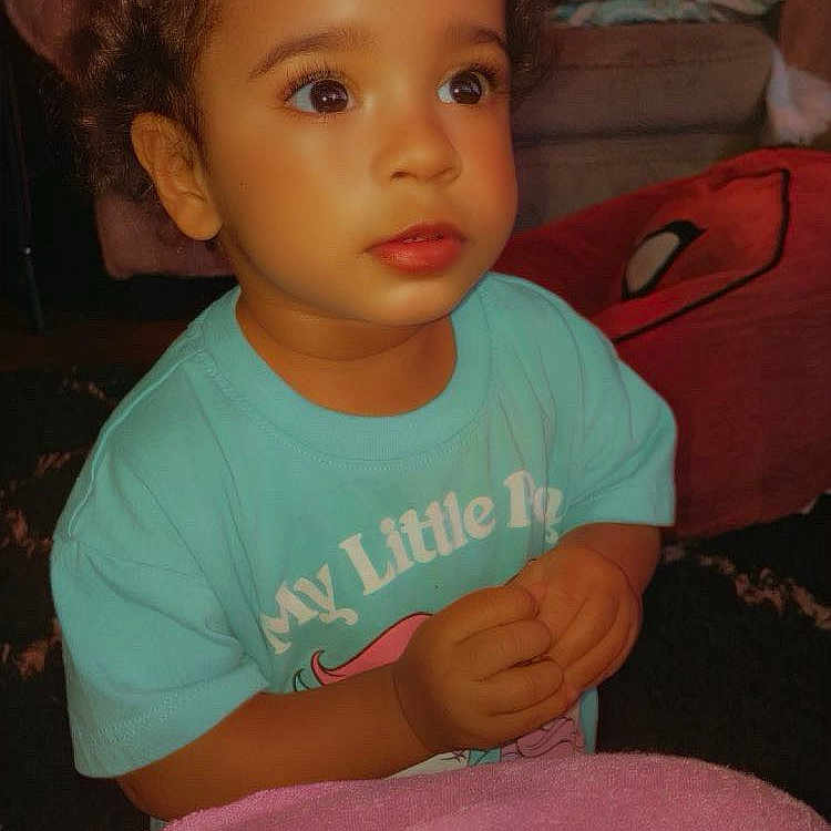 Kahli is registered to the contest to win money with this photo: baby, bed, bedroom, bodypart, clothing, couch, cushion, face, finger, furniture, hair, hand, head, homedecor, indoors, person, photography, portrait, sitting, t_shirt