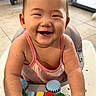 baby, smiling, toy, walker, indoor, child, happy, colorful, piano, floor, window, stroller, hands, face, person, cute, infant, play, joy, tiled_floor
