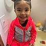 Malia joined the competition — help win amazing prizes! child, smiling, indoor, bathroom, sink, tracksuit, pink_clothing, hair_buns, cute, happy, portrait, person, young_child, casual_clothing, face, seated, small_child, playful, candid, bright_colors