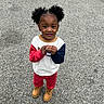 child, toddler, outdoor, gravel, path, sweater, colorful_clothing, red_pants, boots, curly_hair, puffy_hair, standing, looking_up, casual, cute, young_child, person, daylight, nature, curiosity