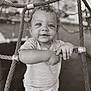 Adrian is registered to the contest to win money with this photo: toddler, child, playground, rope, net, smile, curly_hair, monochrome, outdoor, baby, grip, cute, person, shirt, shorts, expression, young_child, play, fun, daytime