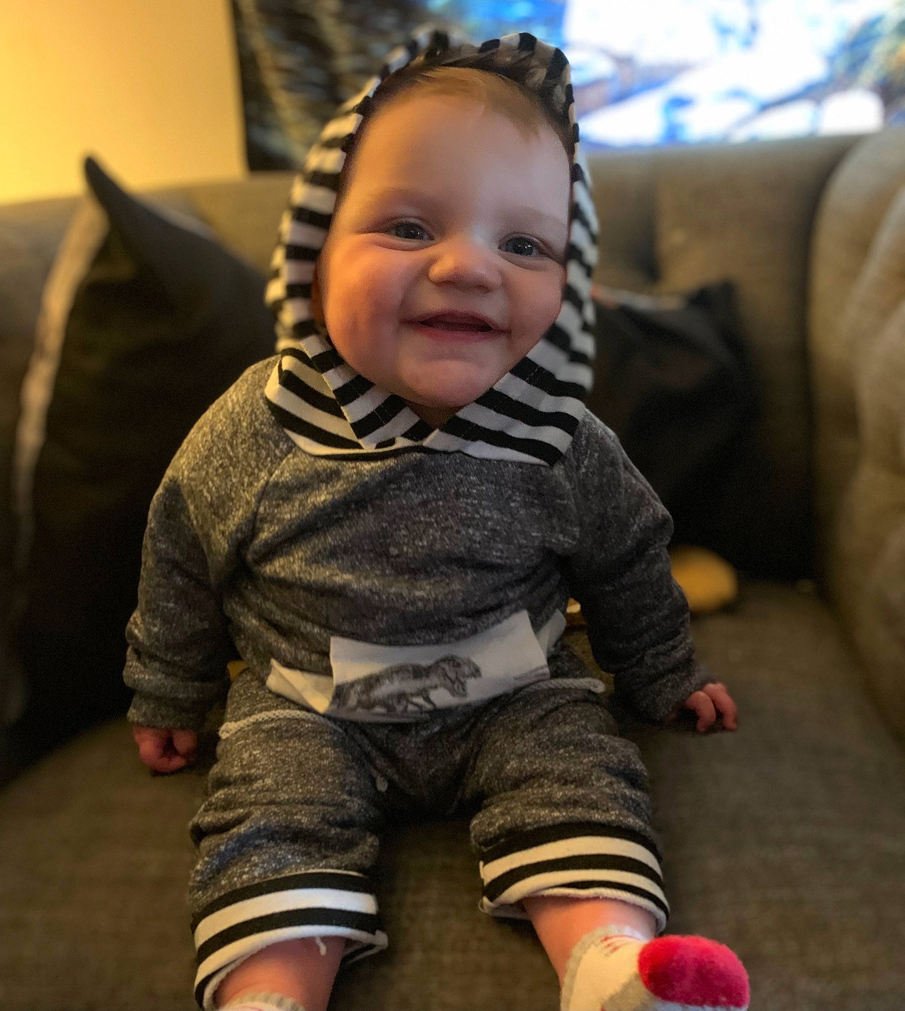 Jaxon is registered to the contest to win money with this photo: baby, baby_toddler_clothing, cheek, comfort, eye, face, finger, flash_photography, flooring, hairstyle, happy, head, iris, joy, mouth, nose, outerwear, person, sleeve, smile