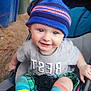 toddler, child, smiling, hat, striped_socks, stroller, blue_eyes, outdoor, casual_clothing, baby, happy, seatbelt, colorful, cute, playful, person, young_child, portrait, infant, clothing