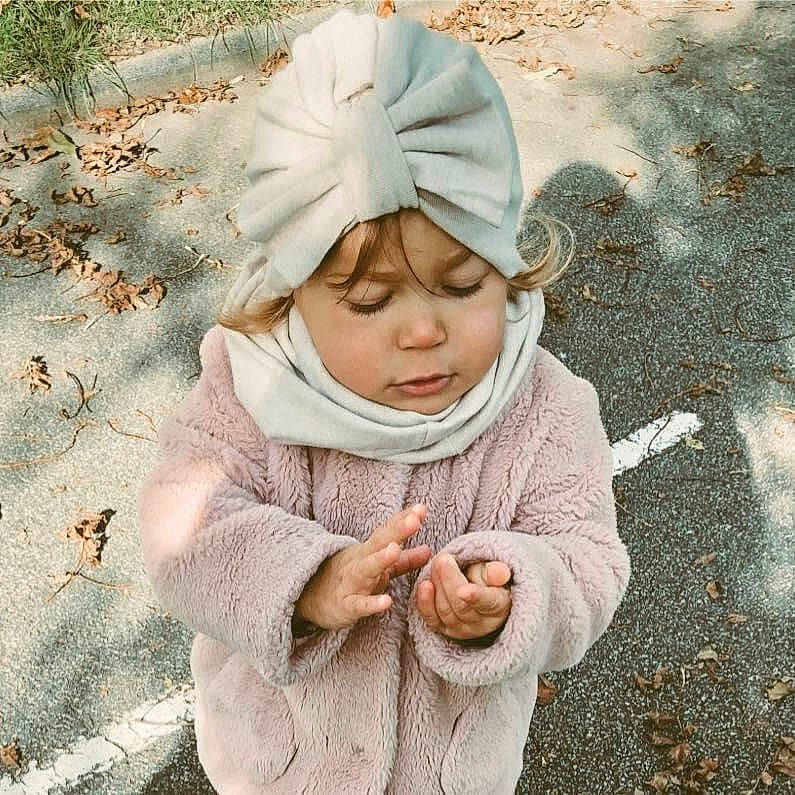 Emma a rejoint le concours — aidez-le/la à gagner de superbes lots ! baby, cap, face, fashion_accessory, freezing, fun, gesture, grass, happy, head, headwear, hood, knit_cap, landscape, linens, pattern, people_in_nature, person, sleeve, spring