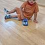 child, toddler, toy_car, floor, sunglasses, bow_tie, mirror, reflection, indoor, playroom, people, shoes, wood_floor, casual_clothing, curly_hair, playing, group, seated, young_child, fun