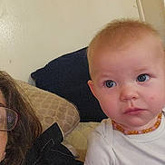 Amber is registered to the contest to win money with this photo: adult, amber_beads, baby, child, close_up, couch, eyeglasses, eyes, face, furniture, hair, home, indoor, infant, necklace, photography, portrait, serious, sitting, white_shirt