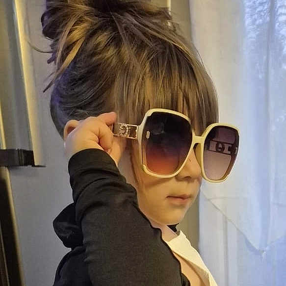 Lucia a rejoint le concours — aidez-le/la à gagner de superbes lots ! child, sunglasses, hair, indoors, curtains, portrait, fashion, young, person, face, hairstyle, window, light, casual, clothing, eyewear, style, cute, confident, accessory