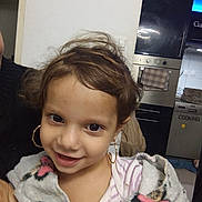 Maria participe au concours pour gagner de l'argent avec cette photo : child, smile, face, hair, earrings, blanket, clothing, indoor, kitchen, appliance, oven, dishwasher, towel, person, portrait, cute, happy, young, cozy, home