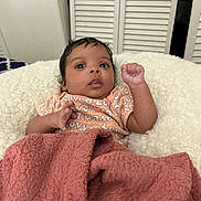 Cherish is registered to the contest to win money with this photo: baby, infant, blanket, cushion, clothing, face, person, indoor, cute, expression, child, newborn, patterned_shirt, pink_blanket, fluffy, portrait, small_hands, curious, lying_down, cozy