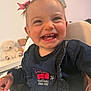 baby, child, childhood, clothing, cute, denim_dress, face, furniture, happy, high_chair, indoor, infant, joyful, person, pink_bow, playful, skin, smile, teddy_bear, toy