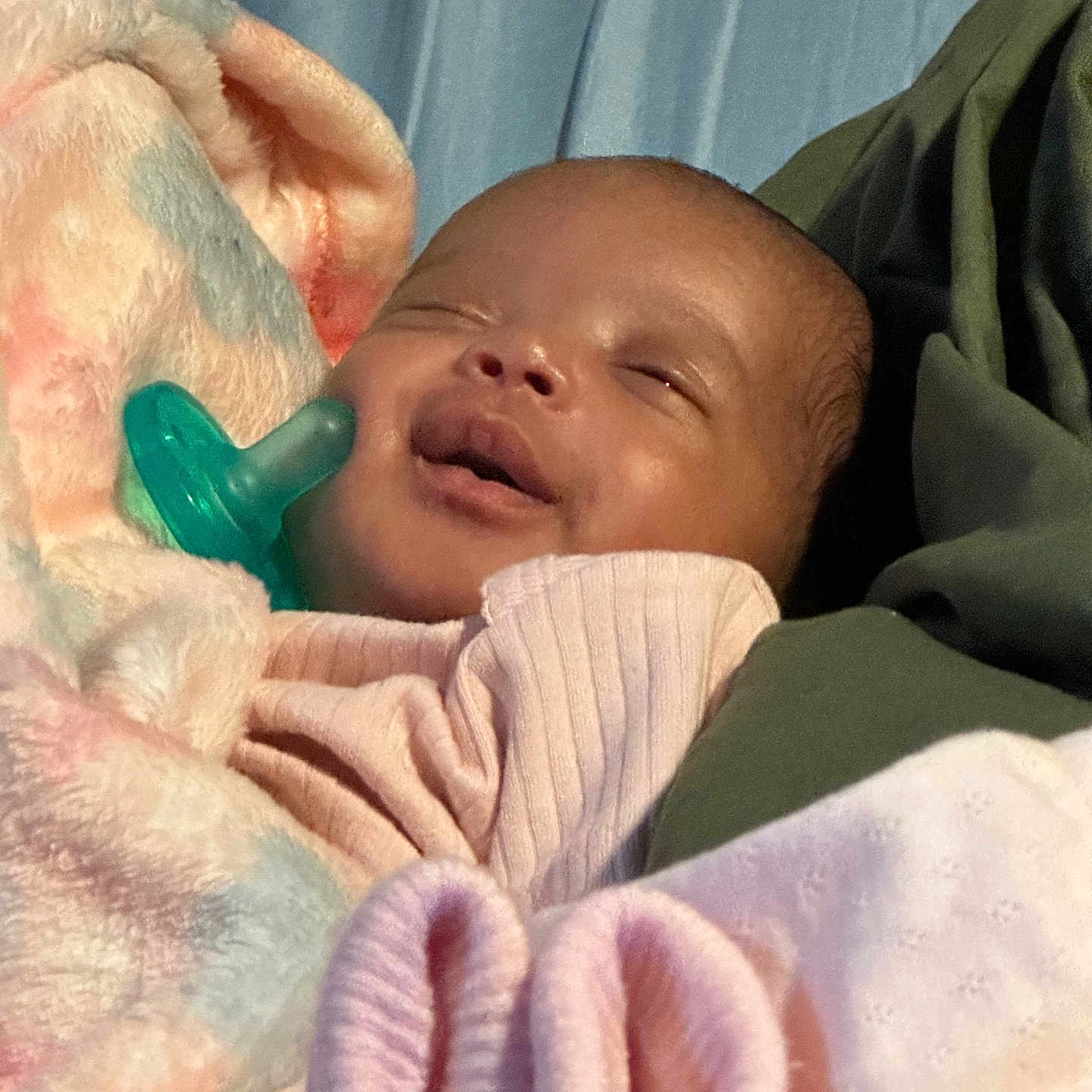 Amirah Wallace is registered to the contest to win money with this photo: baby, smile, pacifier, blanket, sleeping, infant, soft, pastel_colors, cozy, cute, wrapped, child, peaceful, indoors, clothing, face, skin, head, newborn, resting