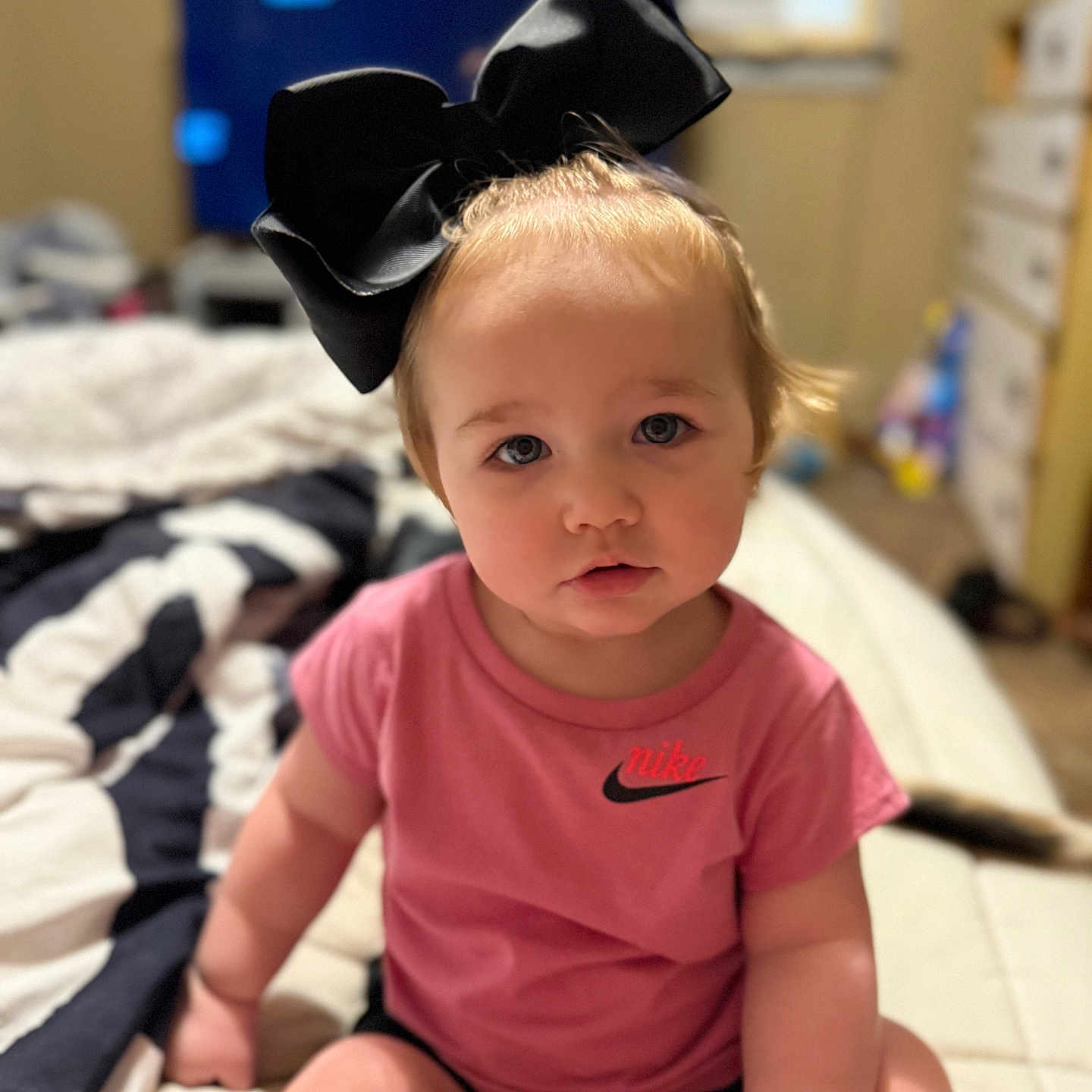 Madilynn joined the competition — help win amazing prizes! accessories, baby, bed, bedroom, bodypart, clothing, couch, face, finger, furniture, hand, hat, head, indoors, person, photography, portrait, room, sitting, t_shirt