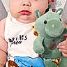 Hansel joined the competition — help win amazing prizes! baby, infant, child, portrait, indoors, lying_down, plush_toy, dragon_toy, blanket, yellow_blanket, checkered_pattern, pillow, baby_clothing, white_shirt, printed_clothing, serious_expression, dark_hair, face, closeup, cozy