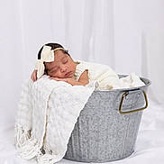 Maite is registered to the contest to win money with this photo: baby, blanket, bow, bucket, cute, face, indoors, infant, metal_tub, newborn, peaceful, photography, portrait, resting, sleeping, soft_lighting, studio, textile, white, wrapped