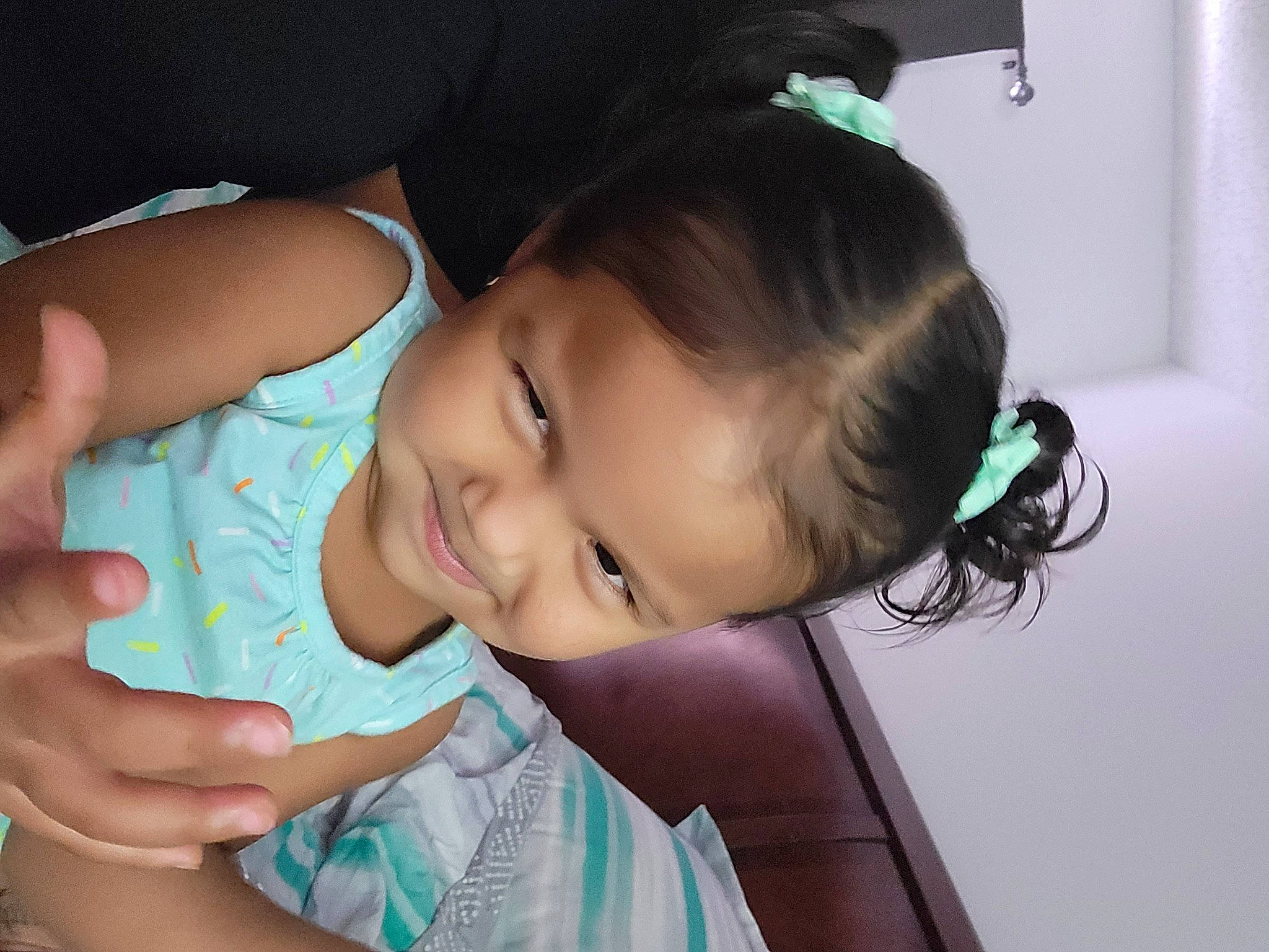 Melanie is registered to the contest to win money with this photo: baby_toddler_clothing, cheek, chin, dress, ear, eyebrow, eyelash, forehead, gesture, hairstyle, hand, happy, human_body, iris, lip, mouth, neck, nose, person, skin