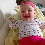 Naomie participe au concours pour gagner de l'argent avec cette photo : baby, infant, smiling, laughing, headband, pink_clothing, heart_pattern, blanket, couch, indoor, child, happy, face, person, young, cute, toddler, playful, relaxed, home
