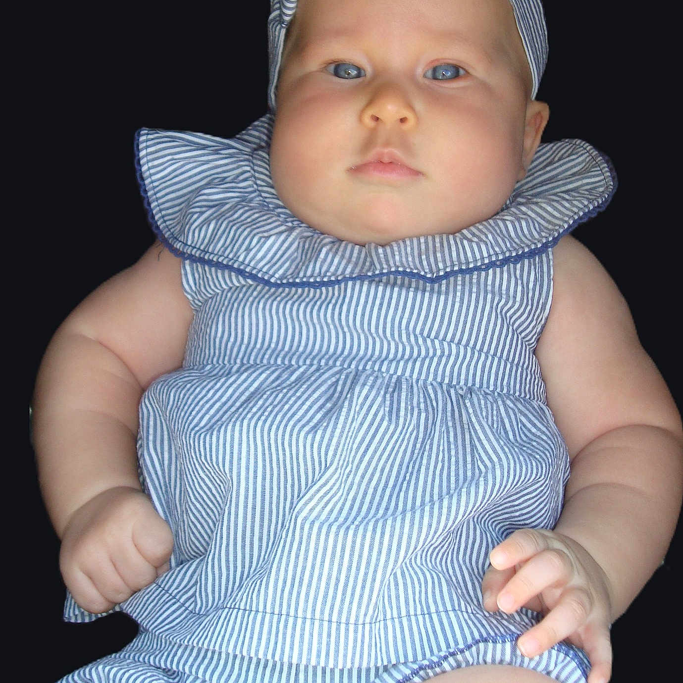 Anava joined the competition — help win amazing prizes! baby, infant, child, portrait, face, blue_eyes, striped_clothing, dress, hat, cap, ruffled_collar, sitting, hands, arms, legs, studio, black_background, close_up, fashion, serious_expression
