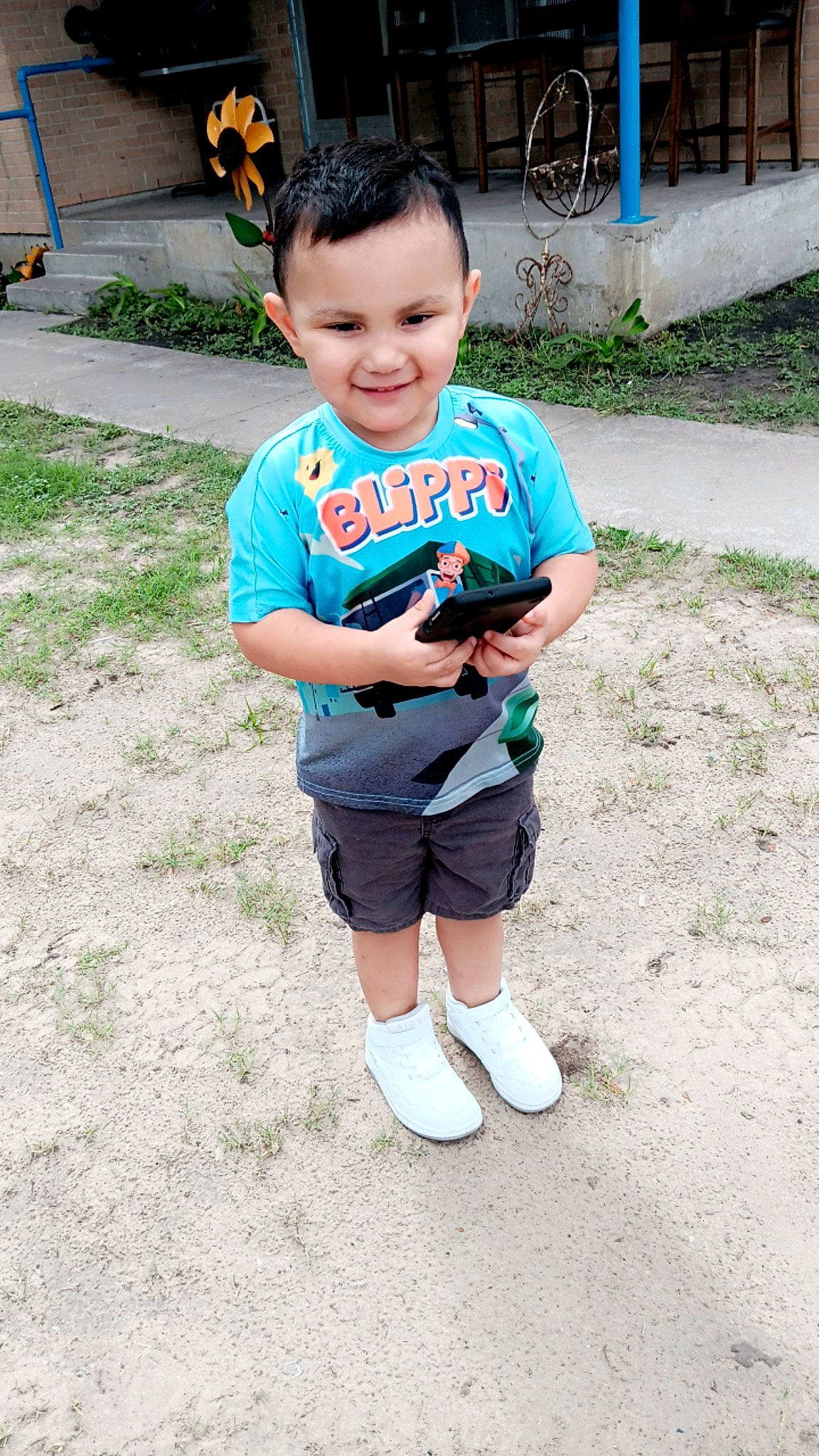 Elijah is registered to the contest to win money with this photo: child, eye, fun, grass, happy, joy, knee, leg, leisure, person, plant, recreation, shorts, sleeve, smile, sock, soil, t_shirt, thigh, toddler