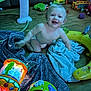 baby, child, diaper, toys, floor, towels, indoor, smiling, playtime, colorful, wooden_floor, lamp, blanket, baby_toys, happy, crawling, person, infant, cute, play