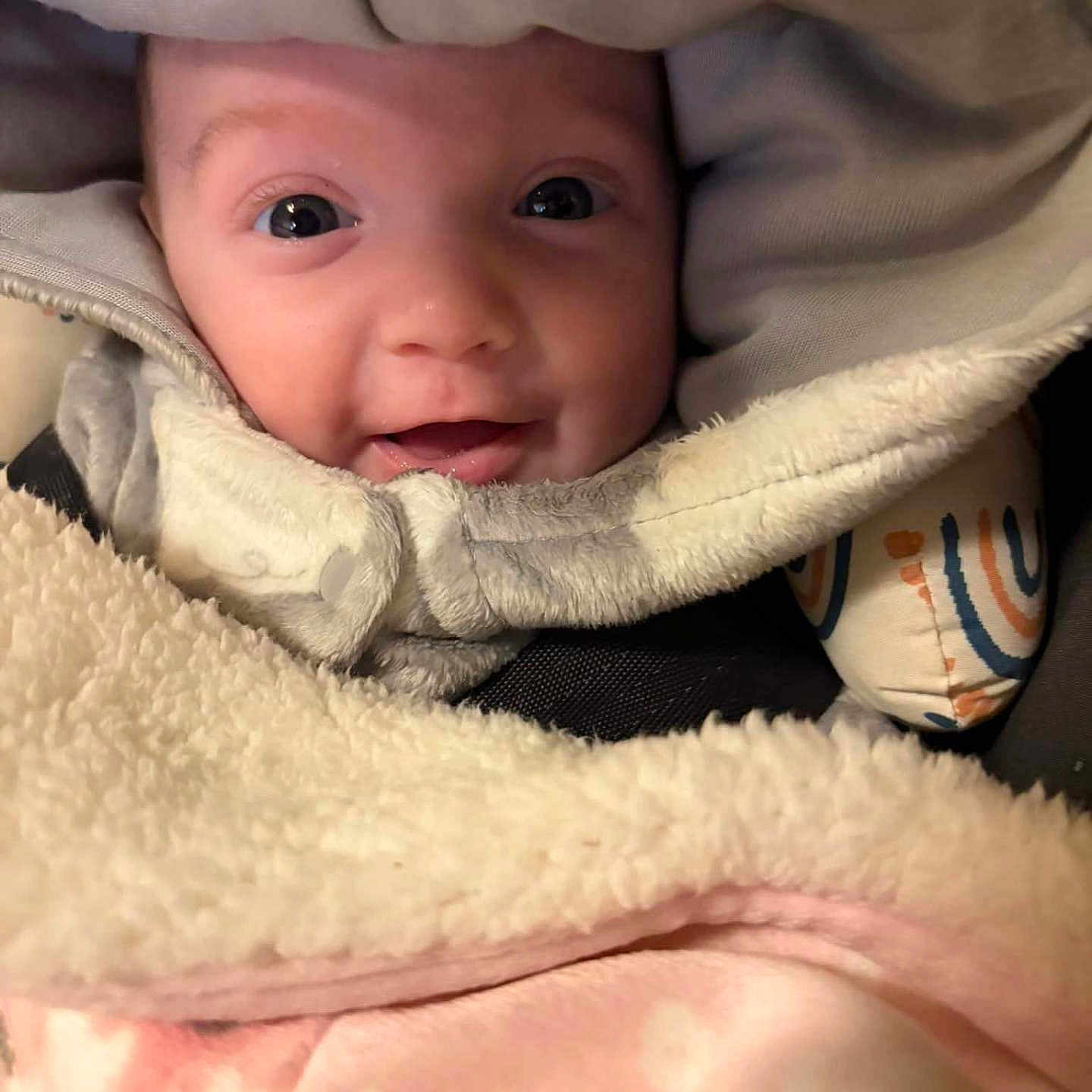 Kelce is registered to the contest to win money with this photo: apparel, baby, blanket, child, closeup, comfort, cozy, cute, face, happy, hood, indoors, infant, person, portrait, smile, soft, textile, warm, wrapped