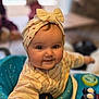 baby, bow, cheeks, child, clothing, curious, cute, face, happy, headband, indoor, infant, person, play, seat, smile, striped, toy, walker, young