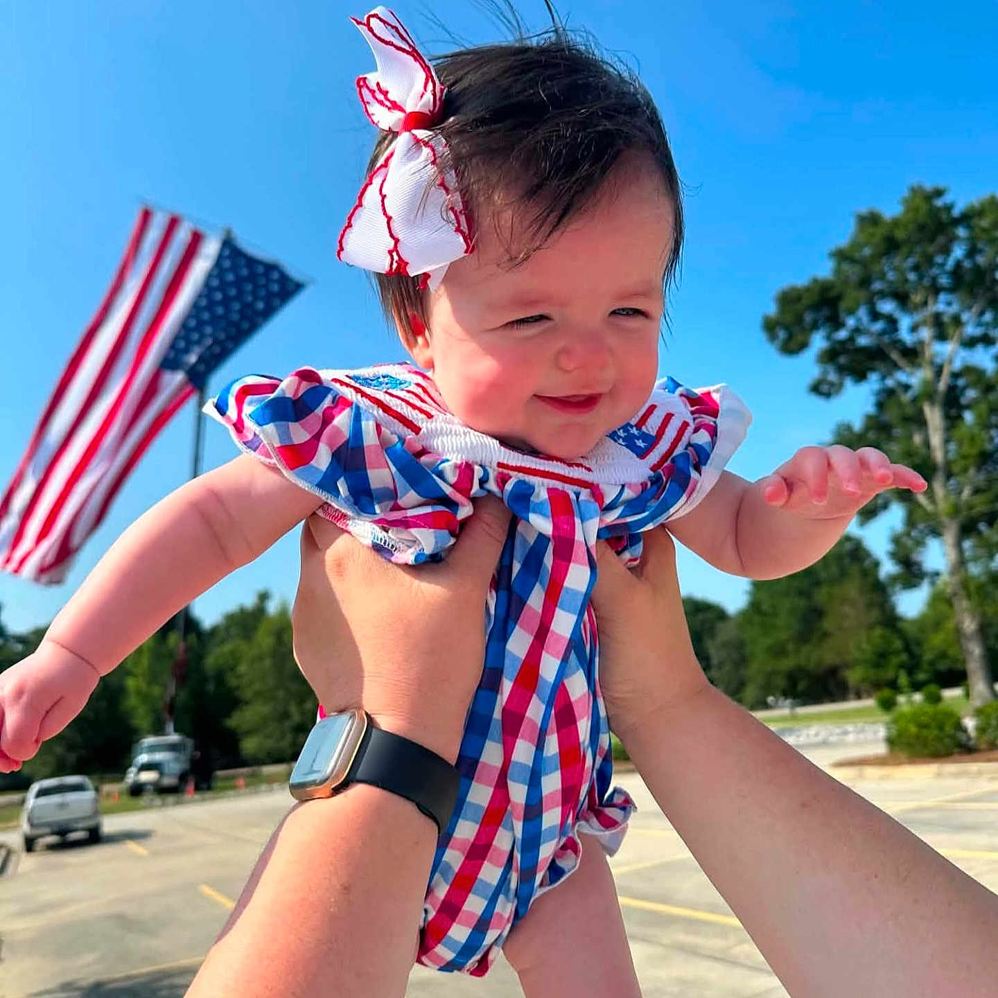 Adalou joined the competition — help win amazing prizes! baby, child, outdoor, blue_sky, american_flag, holding_hands, happy, smiling, bow, dress, person, sunny, daylight, patriotic, cheerful, cute, infant, playing, park, trees