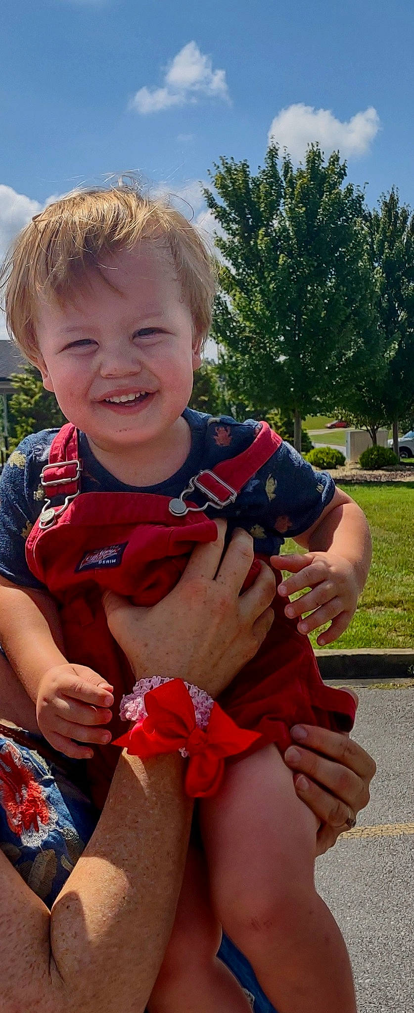 Colby is registered to the contest to win money with this photo: arm, baby_toddler_clothing, child, facial_expression, finger, fun, gesture, grass, hand, happy, human_body, joy, leisure, mouth, person, pink, plant, recreation, smile, thumb