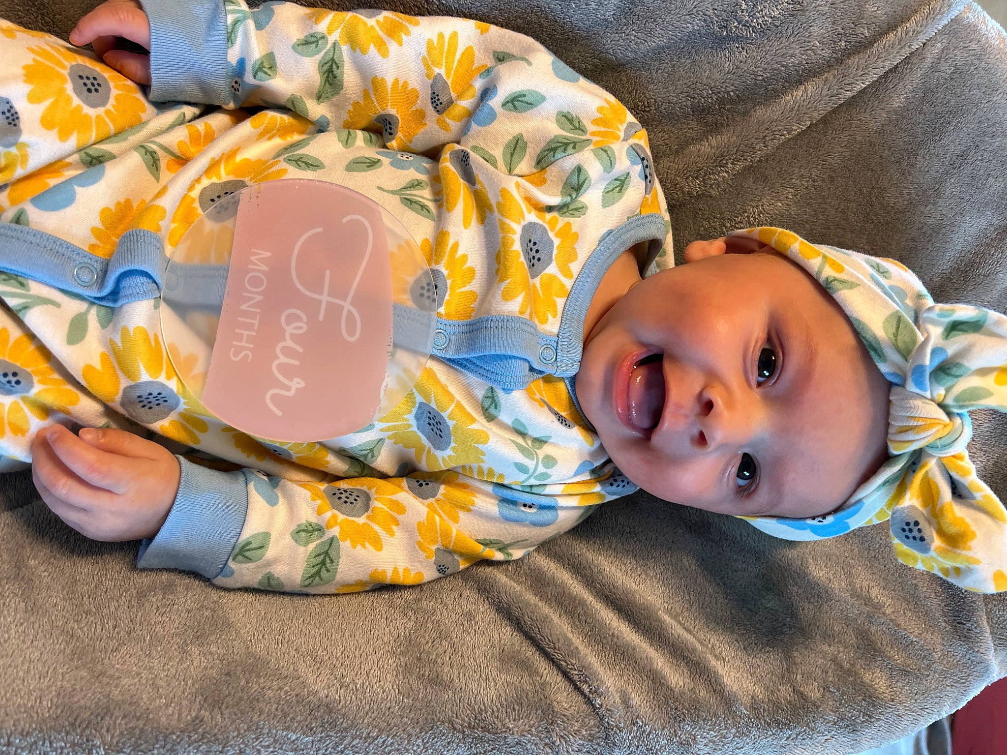 Aubrey is registered to the contest to win money with this photo: baby, baby_toddler_clothing, child, comfort, fun, grass, happy, hat, head, headgear, headwear, leisure, orange, pattern, person, plant, room, sitting, sleeve, smile