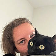 Saki participe au concours pour gagner de l'argent avec cette photo : person, cat, black_cat, animal, pet, hug, close_up, indoor, affection, face, eyes, hair, shoulder, gray_clothing, domestic_animal, feline, cute, companion, cozy, portrait