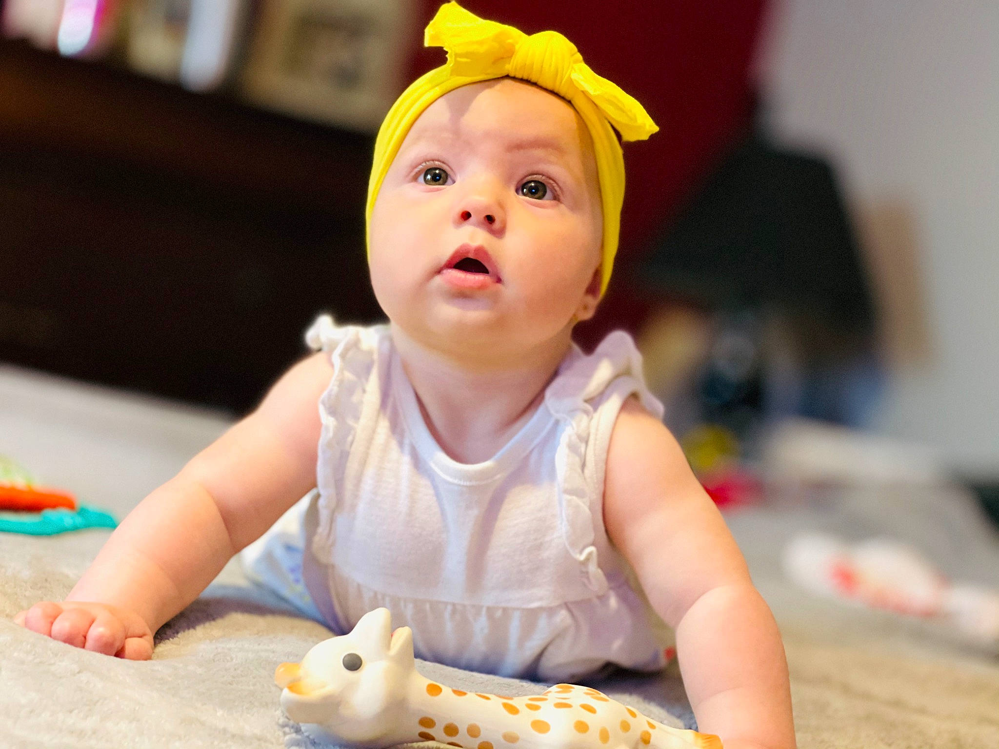 Everly is registered to the contest to win money with this photo: baby, baby_playing_with_toys, baby_toddler_clothing, cheek, child, dress, finger, fun, happy, headwear, leisure, person, play, portrait_photography, sitting, skin, smile, surprise, sweetness, toddler