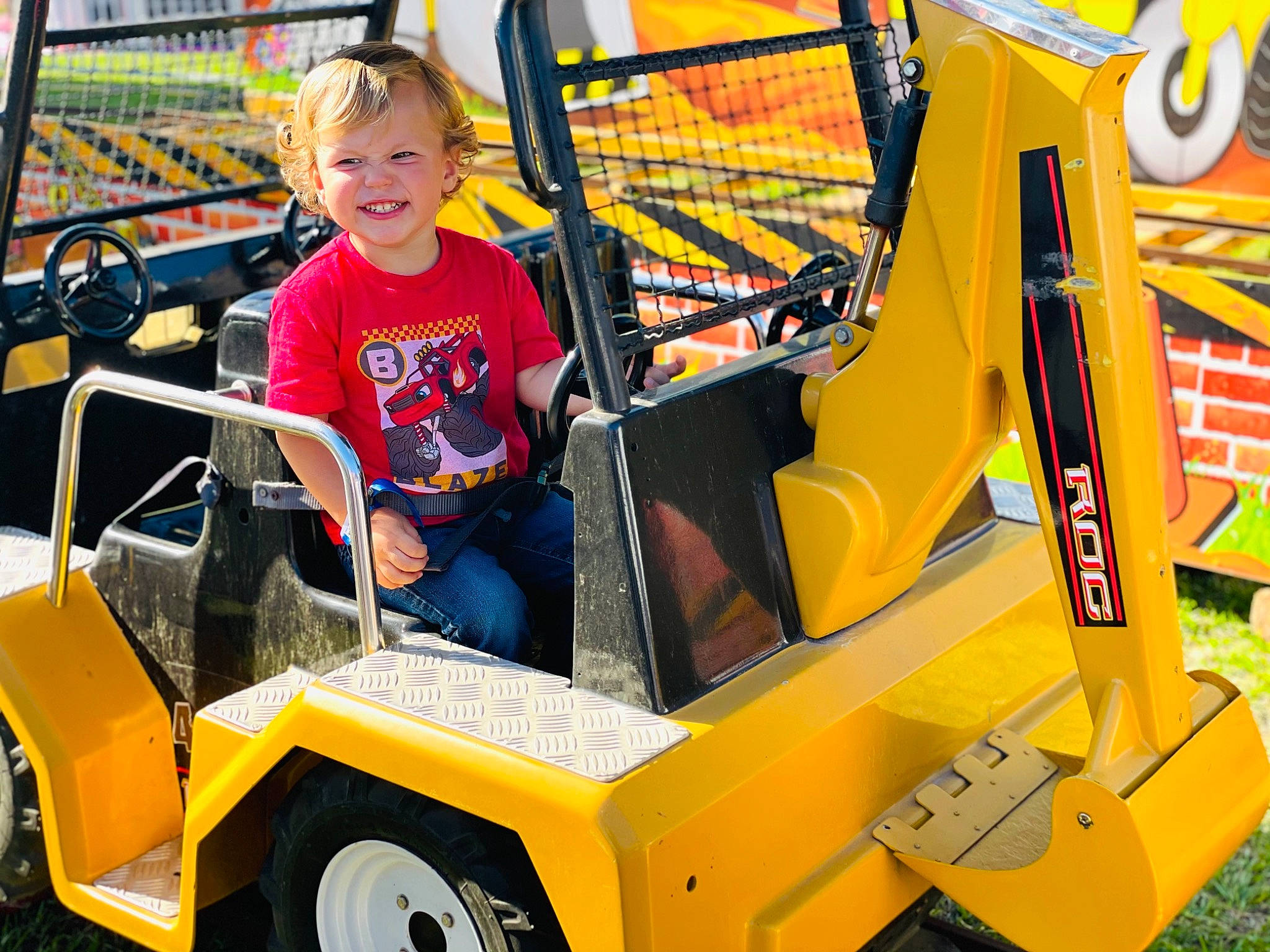 Christian is registered to the contest to win money with this photo: auto_part, automotive_design, automotive_exterior, automotive_tire, automotive_wheel_system, bumper, engineering, event, fun, joy, leisure, motor_vehicle, person, recreation, shorts, smile, t_shirt, tire, toddler, vehicle