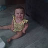 baby, child, smiling, sitting, yellow_clothing, polka_dots, floor, indoor, cute, happy, person, infant, legs, arms, head, face, eyes, mouth, toes, home