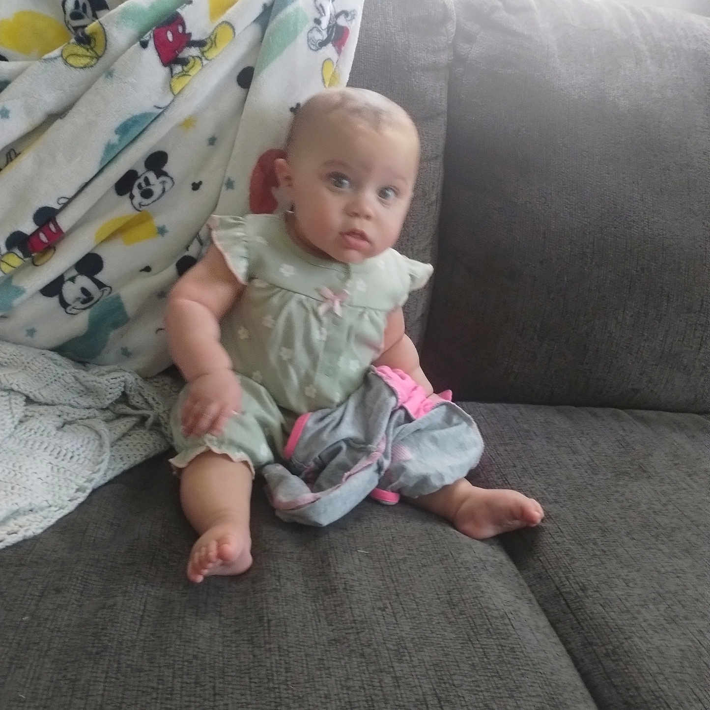Katlieana joined the competition — help win amazing prizes! baby, child, couch, blanket, mickey_mouse, clothing, indoors, infant, person, sitting, foot, face, expression, curious, soft_fabric, home, casual, colorful, plush, cozy