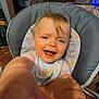 Harlyn is registered to the contest to win money with this photo: toddler, child, smiling, high_chair, baby, indoor, happy, face, hand, furniture, home, bib, wood_floor, cushion, person, clothing, living_room, reaching, cute, playful