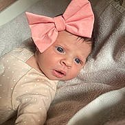 Lucia a rejoint le concours — aidez-le/la à gagner de superbes lots ! baby, infant, bow, pink_bow, face, eyes, clothing, onesie, towel, soft_texture, skin, portrait, cute, newborn, lying_down, expression, indoor, child, person, headwear