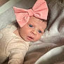 baby, infant, bow, pink_bow, face, eyes, clothing, onesie, towel, soft_texture, skin, portrait, cute, newborn, lying_down, expression, indoor, child, person, headwear