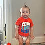 Charles joined the competition — help win amazing prizes! toddler, child, diaper, orange_tshirt, mohawk_hairstyle, indoor, rug, toy, carpet, person, standing, home, curious, serious, floor, wall, door, baseboard, hair, baby