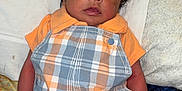 Zamir joined the competition — help win amazing prizes! baby, infant, child, plaid, romper, orange, blue, blanket, pillow, bed, clothing, person, cute, indoors, portrait, newborn, sleepwear, toddler, face, hair