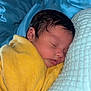 Zamir is registered to the contest to win money with this photo: newborn, baby, sleeping, blanket, yellow_clothing, pillow, hand, soft_texture, closeup, indoor, peaceful, rest, infant, face, skin, person, child, comfort, warmth, quiet