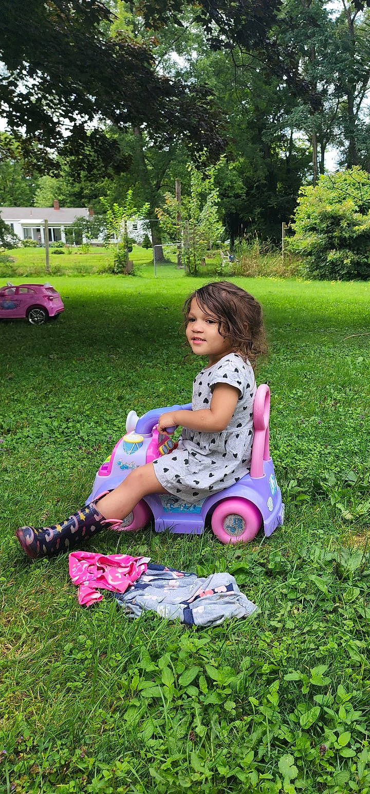 Amarie is registered to the contest to win money with this photo: baby_toddler_clothing, fun, garden, grass, green, happy, lawn, leaf, leisure, magenta, people_in_nature, person, pink, plant, recreation, summer, tire, toddler, tree, vehicle