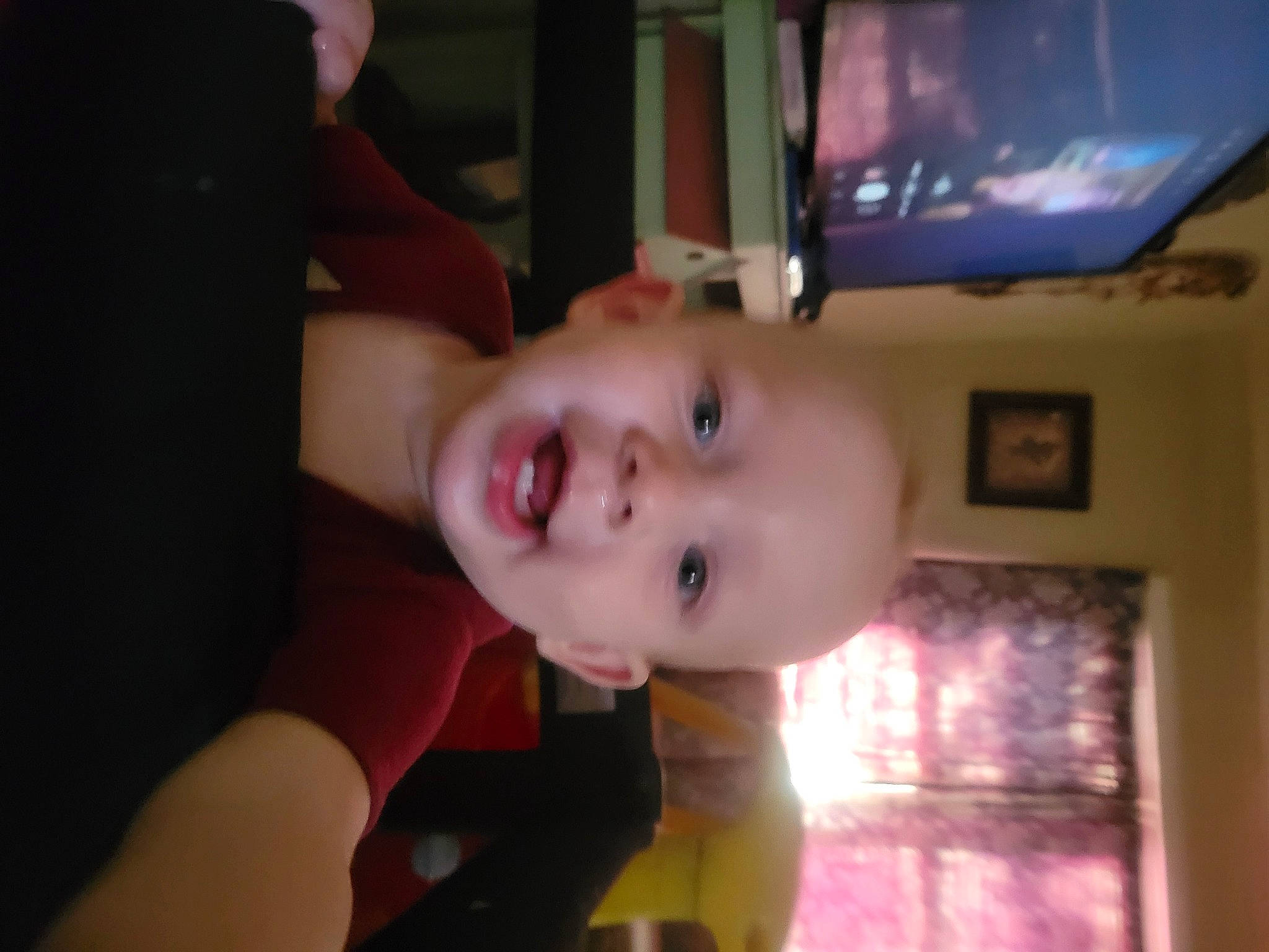 Ryder is registered to the contest to win money with this photo: baby, baby_laughing, baby_toddler_clothing, cheek, chin, display_device, eyebrow, flooring, fun, happy, iris, lip, mouth, nose, person, picture_frame, smile, television, television_set, toddler