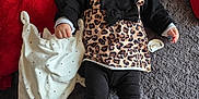 Maria a rejoint le concours — aidez-le/la à gagner de superbes lots ! baby, infant, smile, leopard_print, outfit, blanket, stuffed_animal, pacifier, red_pillow, gray_rug, hand, shoe, socks, portrait, cozy, lying_down, toy, cute, black_clothing, face
