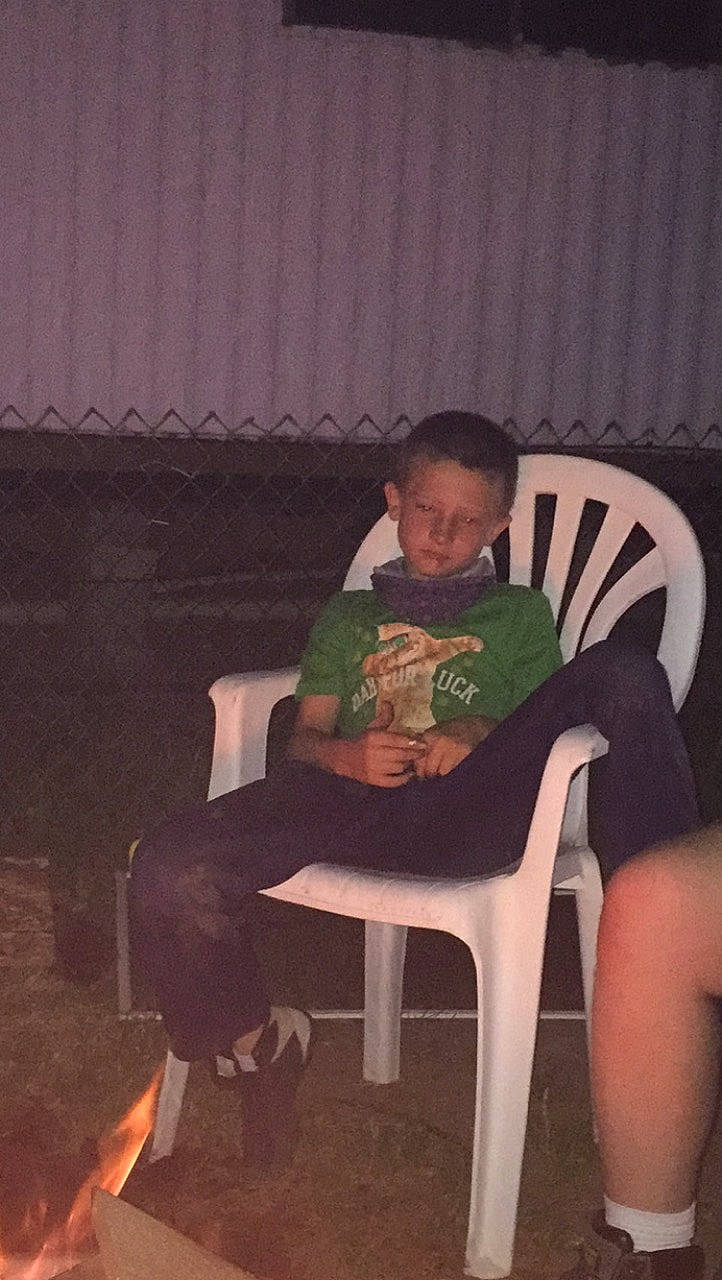 Tavon is registered to the contest to win money with this photo: chair, child, comfort, darkness, event, fun, furniture, human_leg, knee, lap, leg, leisure, night, person, room, shorts, sitting, t_shirt, thigh, tints_and_shades