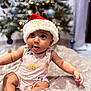 baby, child, santa_hat, christmas_tree, holiday, indoor, blanket, cute, infant, festive, decorations, soft, curious, smiling, happy, seasonal, celebration, portrait, clothing, toddler