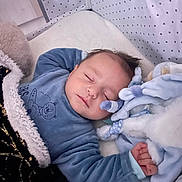 Alessio participe au concours pour gagner de l'argent avec cette photo : baby, sleeping, crib, blanket, plush_toy, blue_clothing, infant, face, peaceful, hand, bed, soft_toys, star_pattern, cozy, child, indoor, cute, rest, young, comfort