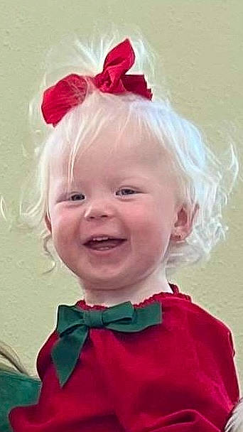 River is registered to the contest to win money with this photo: baby_toddler_clothing, bow_tie, cheek, chin, clothing, costume_hat, eye, eyebrow, face, hair, hairstyle, happy, head, headgear, iris, party_hat, person, pink, smile, toddler